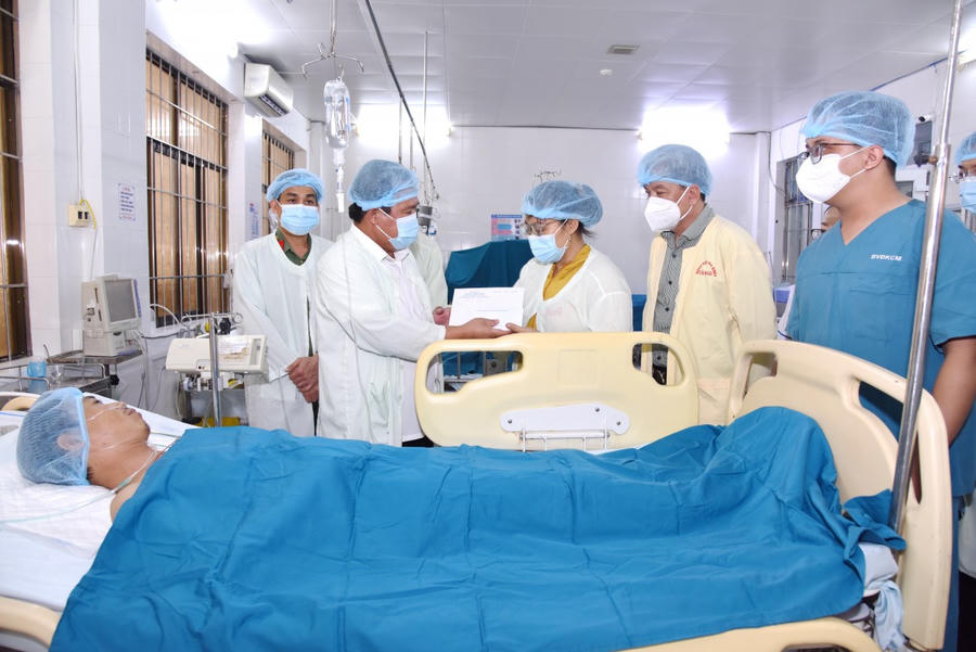 Ông Nguyễn Minh Luân - Phó Chủ tịch UBND tỉnh Cà Mau (thứ 2 từ trái sang) và Đại tá Lê Tấn Vinh - Phó Giám đốc phụ trách Công an tỉnh (thứ nhất, bên trái sang) đến thăm hỏi, động viên và trao kinh phí hỗ trợ điều trị cho anh Trần A Đal.