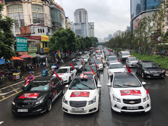 Từng đoàn xe nối dài với màu cờ tổ quốc và hình ảnh các “chiến binh” Olympic Việt Nam. (Ảnh: Lan Phương)