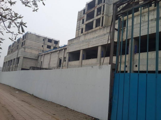 Cốp pha, giàn giáo bao quanh các tòa nhà đã được dỡ đi, để lộ khung bê tông, cốt thép phía bên trong công trường.