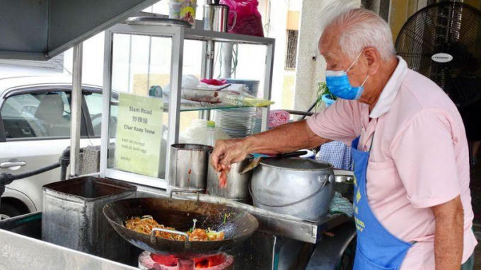 Chế biến món Char Kway Teow nổi tiếng của Malaysia.