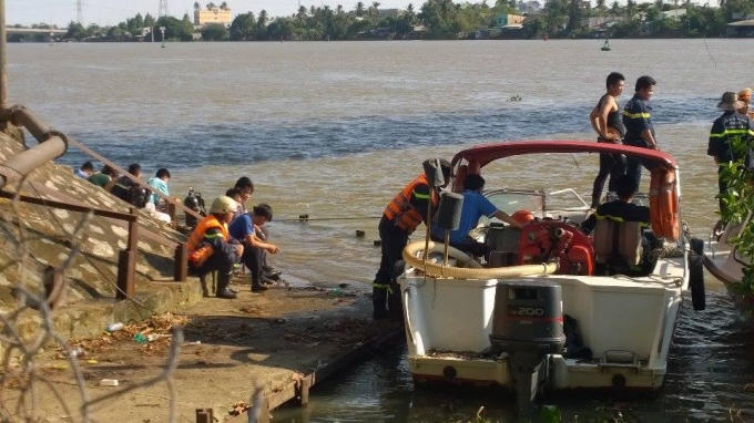 Lực lượng chức năng trục vớt phương tiện rơi xuống sông và di dời sà lan.