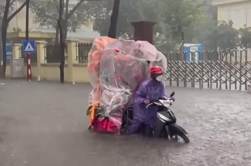 Người dân vất vả mưu sinh trong mưa lớn.