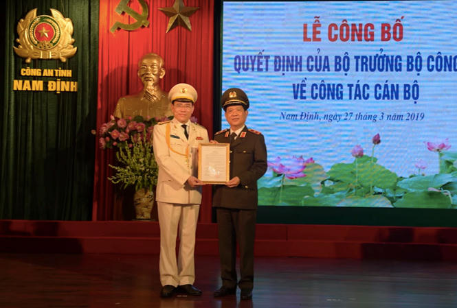 Đồng chí Đại tá Phạm Văn Long (áo trắng) nhận quyết định bổ nhiệm Giám đốc công an tỉnh Nam Định từ thứ trưởng Bộ Công an Trung tướng Nguyễn Văn Sơn (Ảnh: Hoàng Long)