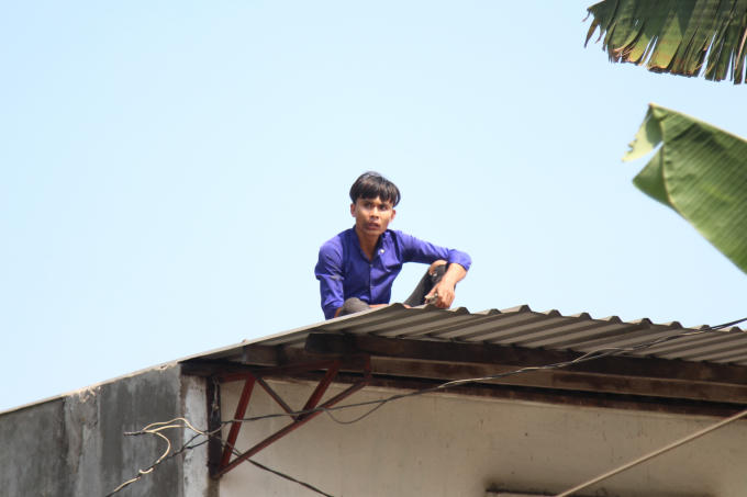 Mặc dù rơi ở độ cao gần 10m nhưng may mắn nam thanh niên này vẫn không bị thương rồi nhanh chóng leo lên nóc nhà dân cố thủ.