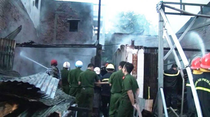 Lực lượng chữa cháy tiến vào một ngôi nhà xịt nước dặp tắt đám cháy