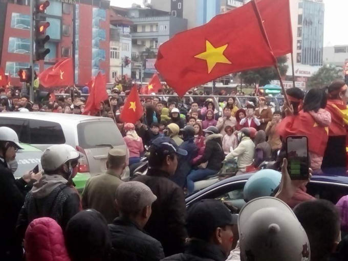 Người hâm mộ đang hô hào chờ đợi chiếc xe buýt đưa các cầu thủ qua đường Võ Chí Công.