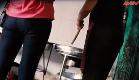 Có mặt tại một cơ sở sản xuất giò chả ở chợ Đông Tảo, Hưng Yên, nhóm phóng viên bắt gặp hình ảnh bà chủ nhanh tay đảo chảo rán mỡ bằng hai chiếc que tre dài.Ảnh: ANTV.