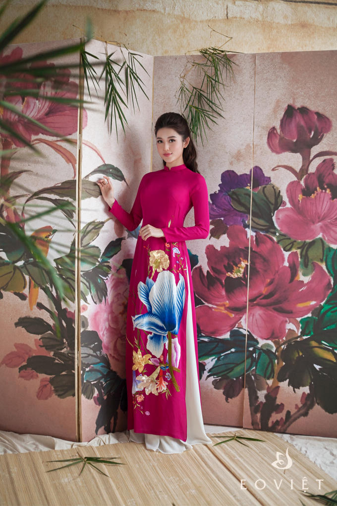 Chiếc áo dài màu hồng cánh sen được tô điểm bởi họa tiết hoa xanh nổi bật. Được chiết may ôm sát nên thiết kế này vẫn giúp nàng á hậu khoe đường cong nóng bỏng của mình.