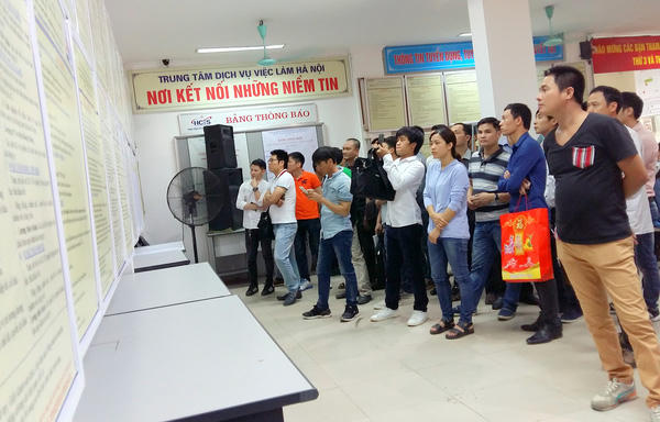 Người lao động tham khảo thông tin việc làm tại Trung tâm Dịch vụ Việc làm Hà Nội (Ảnh: Báo Dân trí)