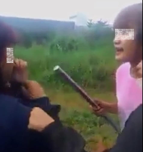 Hai nhân vật chính của clip: Thủ phạm (áo hồng), nạn nhân (áo xanh). Ảnh: Facebook.