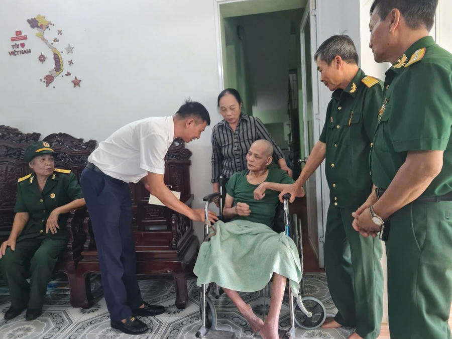 Đại diện nhà xe Quang Mười trao quà cho gia đình thương binh tại phường Cửa Ông.