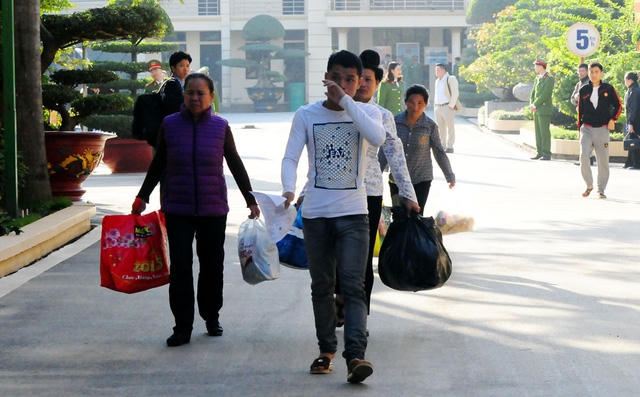 Một thanh niên nén lau những giọt nước mắt khi nhận ra khuôn mặt của người thân đến đón mình đằng sau cánh cửa trại giam.
