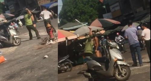 Hình ảnh người đàn ông mặc đồng phục áo bảo vệ dùng vật cứng đánh vào người nam thanh niên.