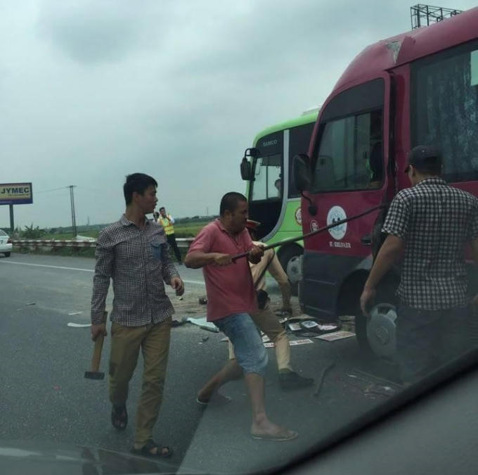 Người dân dùng xà beng cạy cửa cứu tài xế xe khách. (Ảnh: Otofun.net)