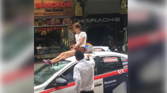 Cô gái ngồi trên nóc taxi giữa đường TP Hà Nội.