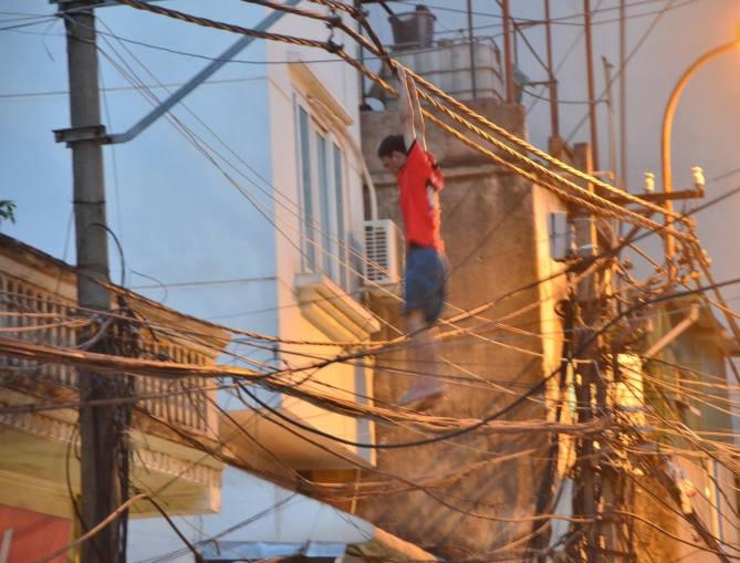 Nam thanh niên làm xiếc trên dây điện.