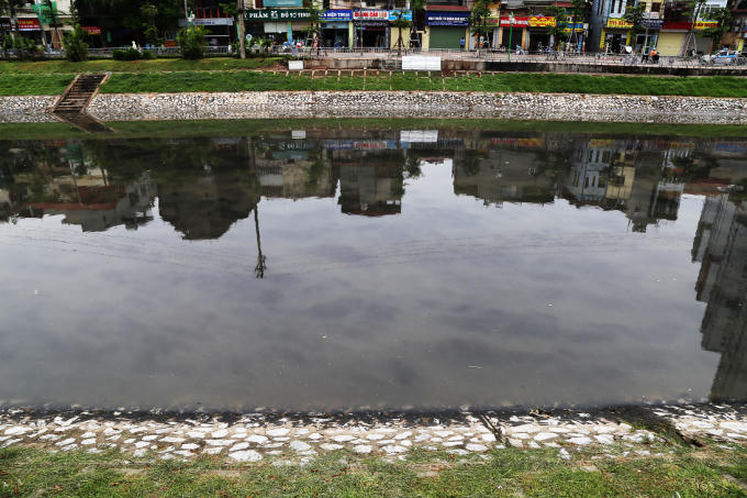 Những thứ cặn bã màu đen dạng lỏng kết dính vào nhau tạo thành tảng trôi khắp sông, khiến những người công nhân dọn rác bó tay.