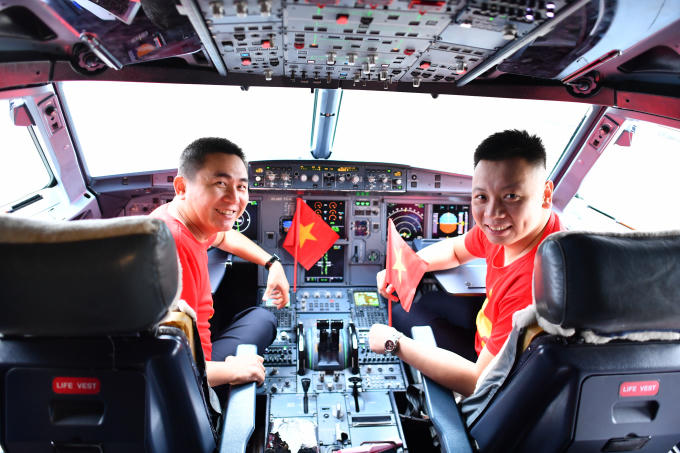 Nụ cười rạng rỡ v&agrave; đầy tự h&agrave;o của 2 phi c&ocirc;ng Vietnam Airlines khi kho&aacute;c l&ecirc;n m&igrave;nh chiếc &aacute;o cờ đỏ sao v&agrave;ng.