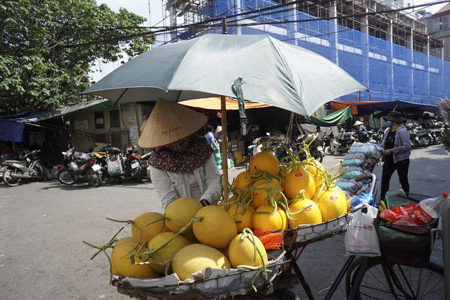 Người bán hoa quả trang bị khăn áo đầy đủ và cắm chiếc ô trên xe để tránh hỏng hoa quả trong thời tiết khắc nghiệt.