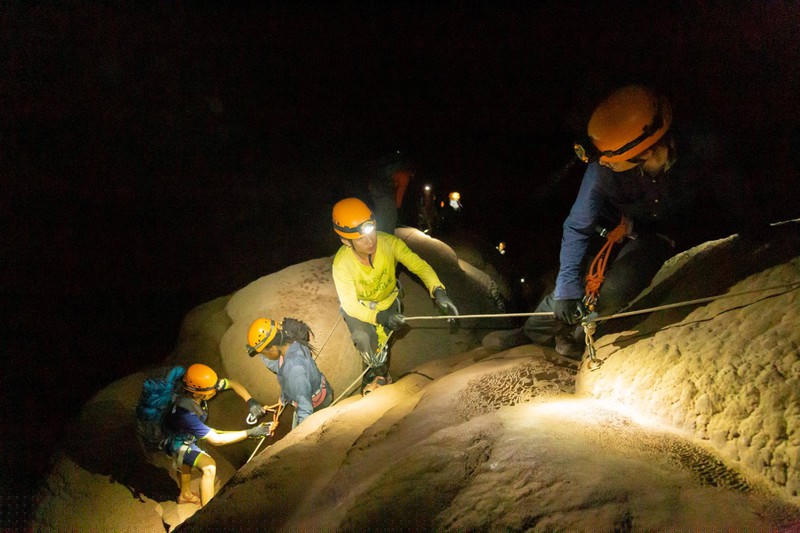 Các porter đang hỗ trợ du khách trong quá trình leo vách hang động để khám phá trải nghiệm. 