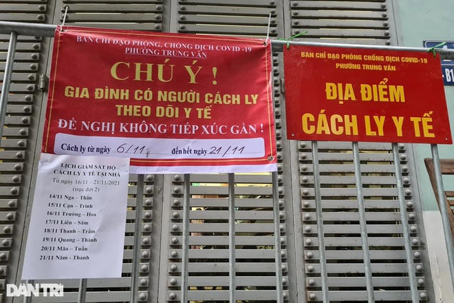 Lực lượng chức năng dán thông báo trước những ngôi nhà có F1 đang tự cách ly tại phường Trung Văn, Nam Từ Liêm (Ảnh: Trần Thanh).