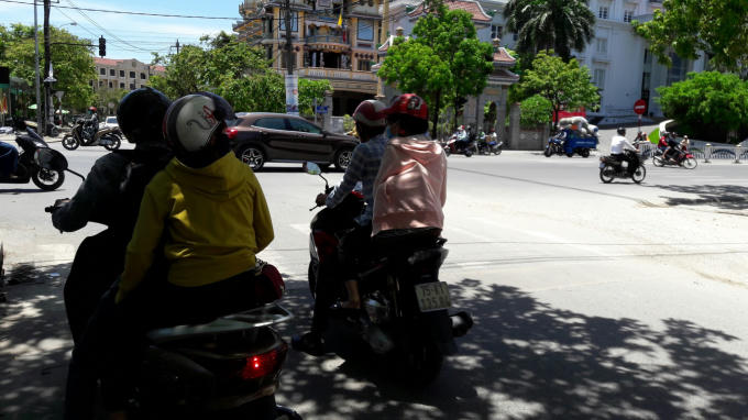 Trên nhiều tuyến đường, người dân tranh thủ đứng chờ đèn đỏ dưới những tán cây xanh để “giảm nhiệt”.