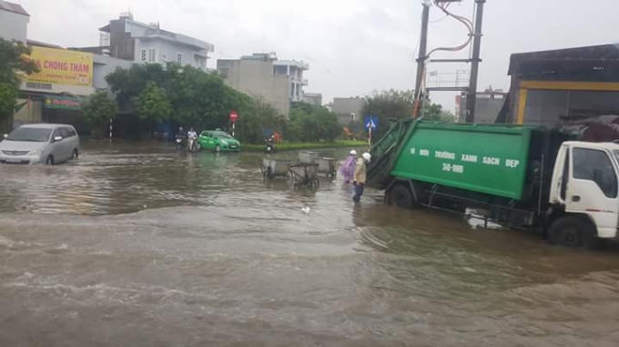 Các xe của Xí nghiệp Môi Trường Xanh đi thu vớt rác nổi vì ngập nước.
