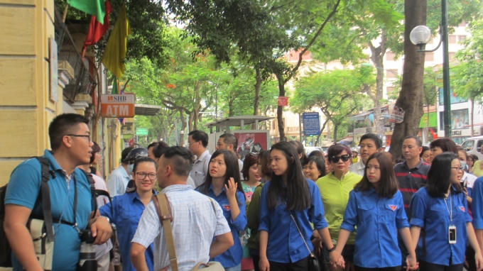 Phụ huỳnh và các bạn tình nguyện đều hướng mắt về cổng trường đề chào đón những sĩ tử hoàn thành bài thi sáng nay. (ảnh: Thu Hường)