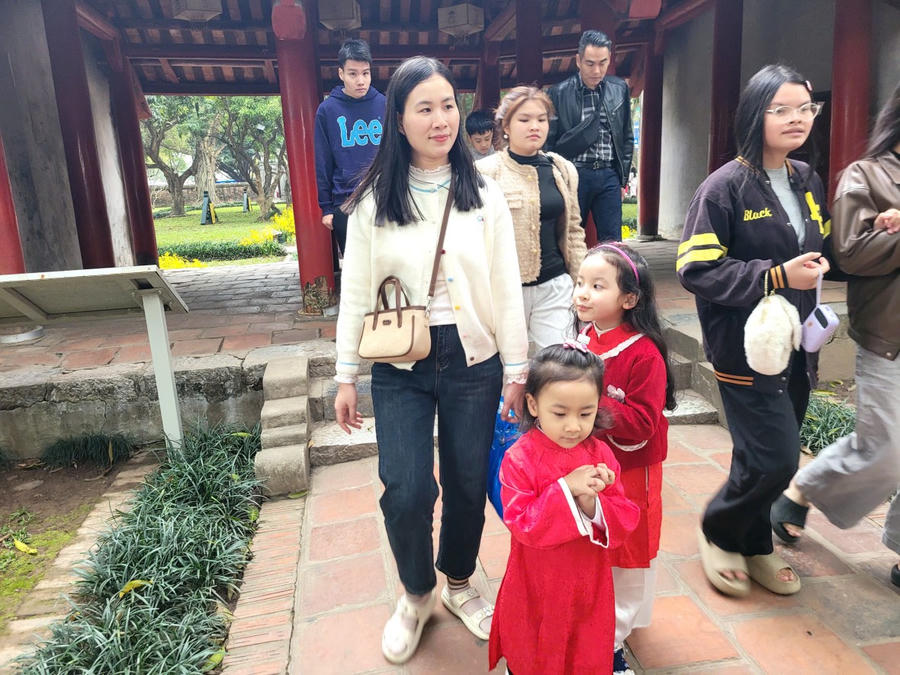 Nhiều gia đình đưa theo con nhỏ xúng xính trong tà áo dài truyền thống, hân hoan du xuân trong không gian cổ kính. (Ảnh: Phạm Duy)