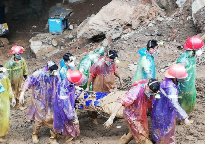 Thi thể một trong hai nạn nhân được lực lượng cứu hộ đưa ra khỏi khu vực bị vùi lấp.