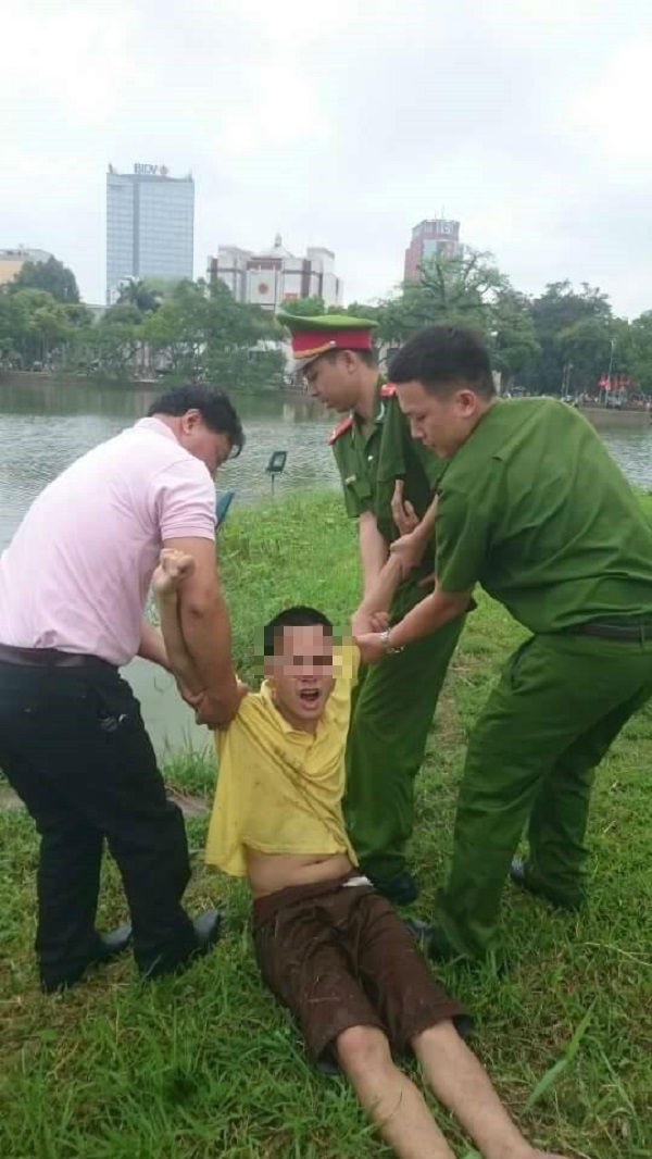 Lực lượng Công an tiến hành cưỡng chế nam thanh niên có biểu hiện "ngáo đá" đưa vào bờ.
