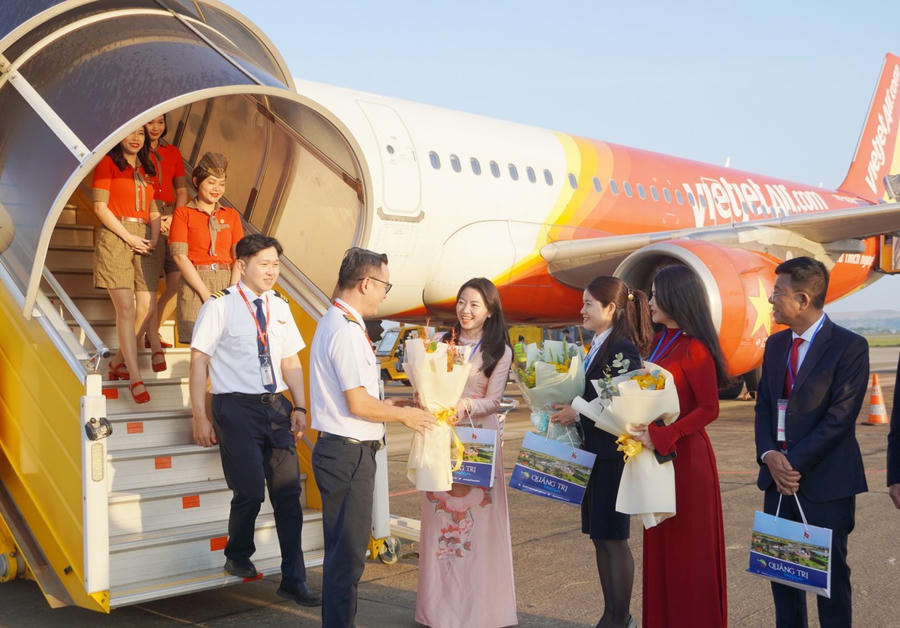 Đại diện lãnh đạo Sở Văn hóa - Thể thao và Du lịch tặng hoa, chúc mừng phi hành đoàn trên chuyến bay đầu năm mới 2026. (Ảnh: Cổng TTĐT tỉnh Quảng Trị)