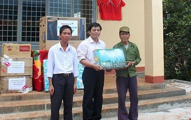Phó Tổng Biên tập Báo PLVN Vũ Hoàng Diệp (giữa) trao quà cho đồng bào có hoàn cảnh khó khăn.