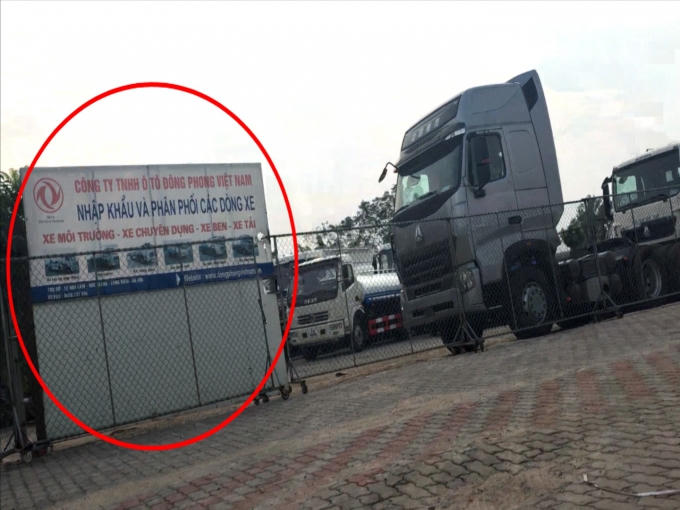 Bãi trưng bày xe tải, xe chuyên dụng trên đất nông nghiệp với biển hiệu của Công ty TNHH ô tô Đông Phong.
