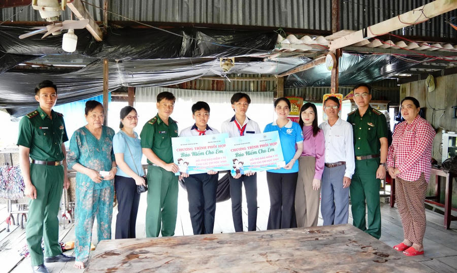 Cán bộ Đồn Biên phòng Đất Mũi và Hội Liên hiệp Phụ nữ xã Đất Mũi trao thẻ BHYT cho học sinh có hoàn cảnh khó khăn.