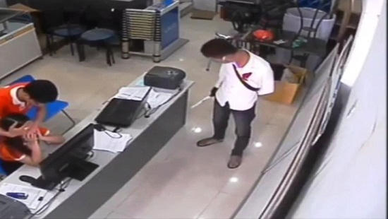 Một đối tượng áo trắng đeo khẩu trang cầm theo dao. (Ảnh: cắt clip).