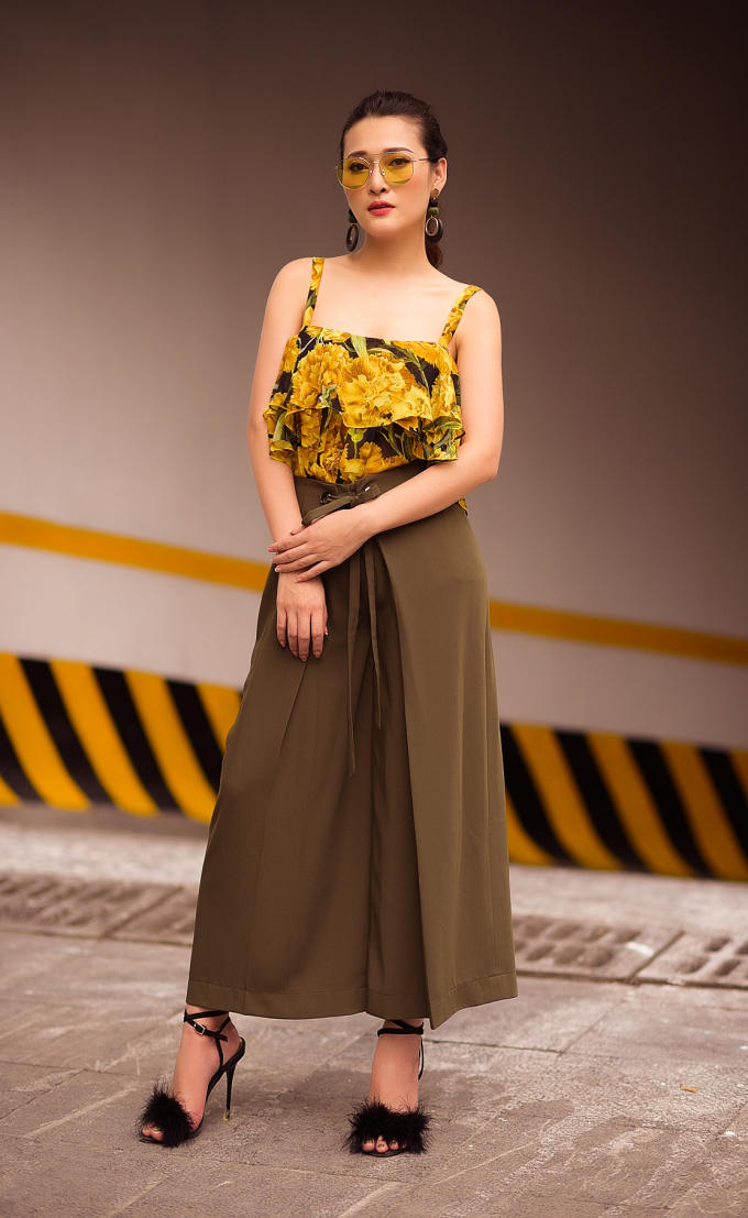 Thứ sáu, Thùy Linh theo đuổi mốt quần quấn với áo bèo nhún ở ngực. Người đẹp gợi ý những cô gái có vòng một nhỏ nhắn nên chọn kiểu áo này, bởi phần xếp bèo bồng bềnh trước ngực có tác dụng ăn gian kích thước vòng một, giúp người mặc trông đầy đặn hơn. Để tăng điểm phong cách, Thùy Linh mix thêm kính phi công có tròng mắt vàng - mốt phụ kiện gây sốt ở mùa mốt năm ngoái được nhiều ngôi sao săn lùng.