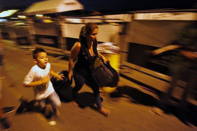 Một phụ nữ dắt theo bé trai chạy băng qua cây cầu Simon Bolivar ở biên giới giáp với Venezuela. Tổng thống Venezuela, ông Nicolás Maduro mới đây đã ký sắc lệnh yêu cầu niêm phong đường biên giới trong vòng 72 giờ (Ảnh: Schneyder Mendoza / AFP / Getty Images)