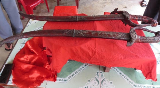Hai thanh kiếm lưỡi sắt có cán gỗ chạm hình rồng phượng sơn son thiếp vàng, một trong các đồ vật vua ban.