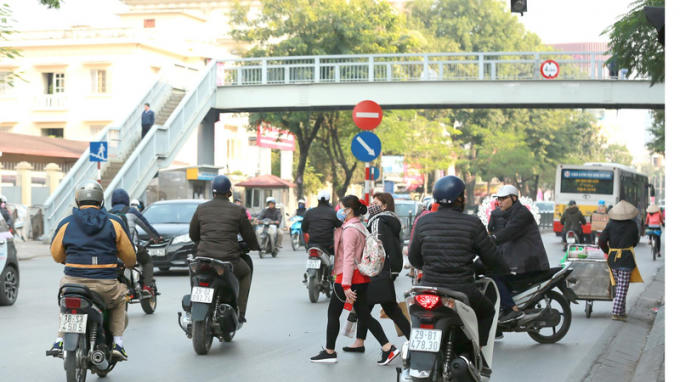 Người đi bộ vẫn băng qua đường, bỏ qua cầu vượt bộ hành.