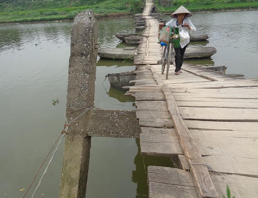 Cây cầu đang trong tình trạng xuống cấp nghiêm trọng. Các cột trụ bê tông xiêu vẹo phải giữ lại bằng dây thép.