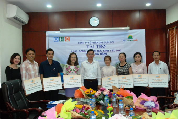 Ông Lại Anh Dũng - Phó Tổng Giám đốc DHC Group (giữa) trao đồng hồ cho Phòng giáo dục đại diện 7 quận, huyện.