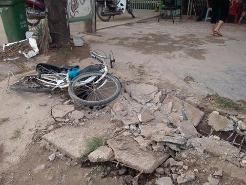 Vụ tai nạn khiến cho bé gái đi xe đạp bị thương còn chiếc xe ô tô 7 chỗ màu đen bị hư hỏng nặng phần đuôi xe.