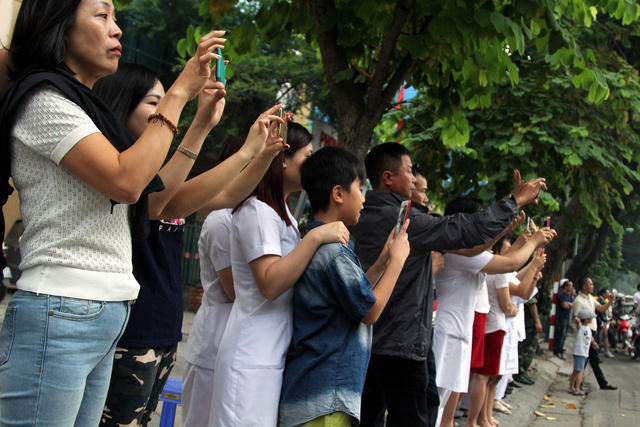 Trong lúc đoàn xe tháp tùng Tổng thống Mỹ tới Phủ chủ tịch, người dân đã tập trung dọc nhiều tuyến phố để đón và chụp ảnh đoàn.