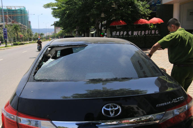 Cơ quan chức năng đang kh&aacute;m nghiệm một chiếc xe &ocirc; t&ocirc; bị kẻ gian đập ph&aacute;.