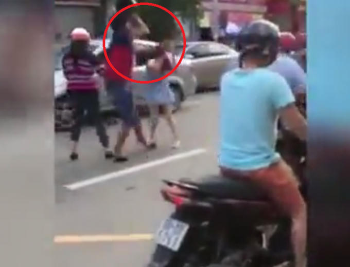 Hình ảnh nam thanh niên dùng mũ bảo hiểm đánh vào đầu cô gái.