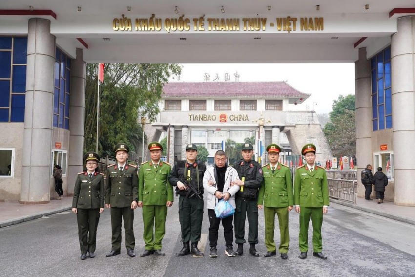 Lực lượng chức năng tỉnh Tuyên Quang trao trả đối tượng bị truy nã quốc tế cho cơ quan chức năng Trung Quốc. (Ảnh: Công an tỉnh Tuyên Quang).