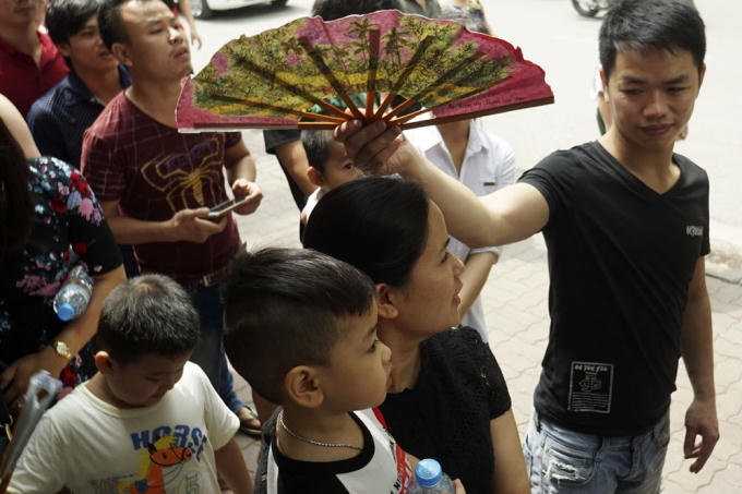 Các cháu nhỏ khá vất vả khi theo người lớn xếp hàng cả tiếng đồng hồ