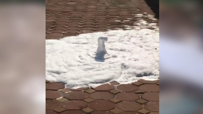 Bọt nước phun lên từ vỉa hè được cho là đường ống nước thải của nhà máy Samsung Thái Nguyên bị rò rỉ. (Ảnh cắt từ clip)