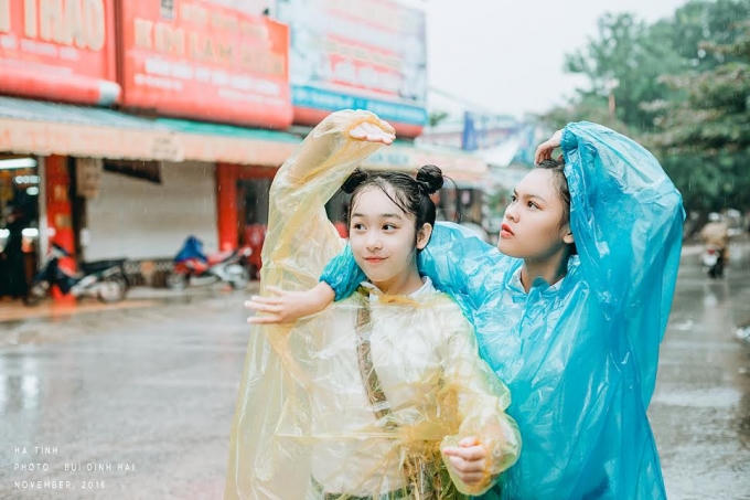 Hoài Thương (áo vàng) và Huyền Trang dưới cơn mưa mùa lũ.